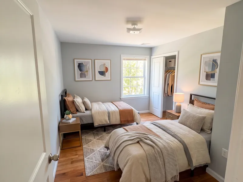 Shared bedroom at DB House with two beds, closet, and hardwood floors