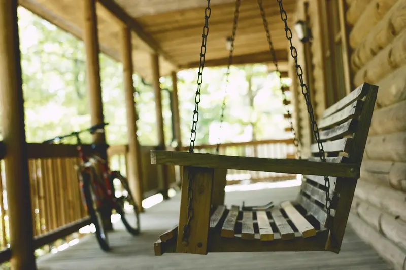 Front porch with a bench and a bicycle in the evening light