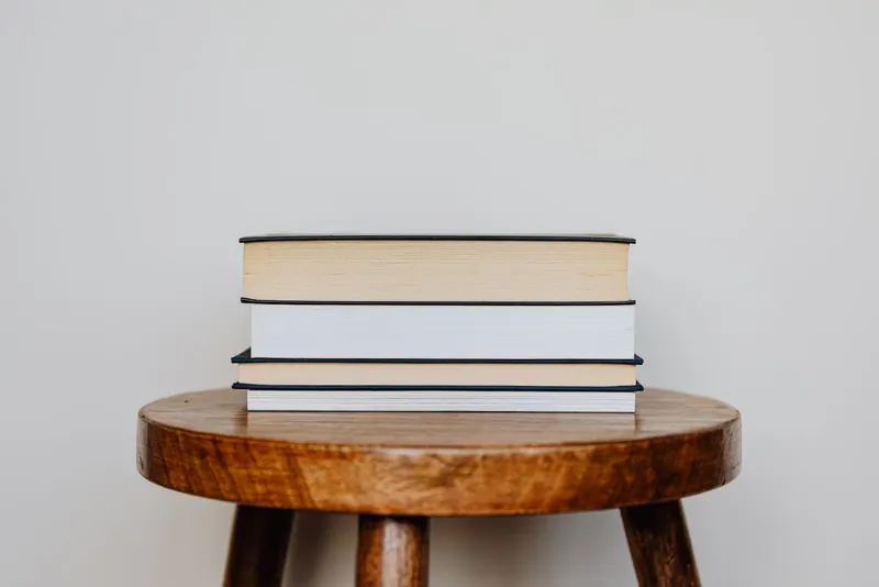 A small stack of books on a wooden stool
